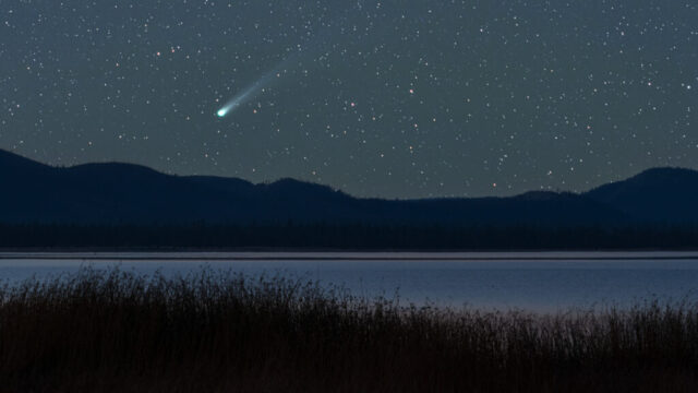 Comet C/2025 A6 Lemmon Over Eagle Lake Night sky photograph of Comet C/2025 A6 (Lemmon) captured over Eagle Lake in Northern California on October 18, 2025. The comet’s bright green nucleus and long, tapering dust tail glow vividly against a star-filled sky, rising above the silhouetted ridgeline and still waters of the lake. Foreground grasses and the calm reflection of twilight lend a sense of quiet isolation and vastness. Shot using a tracking mount for precise long exposure, this astrophotography image showcases the beauty of a rare celestial visitor and the pristine darkness of Eagle Lake’s remote landscape. A fine art nightscape blending cosmic wonder with the tranquil mood of the high desert wilderness.