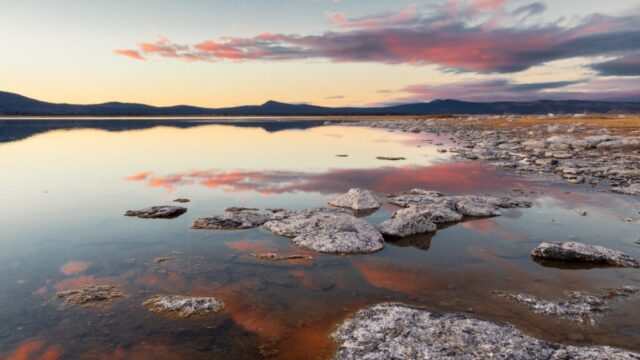 20251205_Looking North_Social_SRGB_001 Rocky shoreline at Miner’s Point on the eastern shore of Eagle Lake, showing calm dusk reflections of pastel clouds and distant ridges while looking north on a December evening.