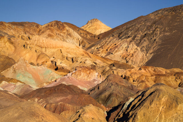 Oxidized mineral hills in layered gold, rust, and earth tones at Artist's Palette, Artist Drive, Death Valley National Park, California