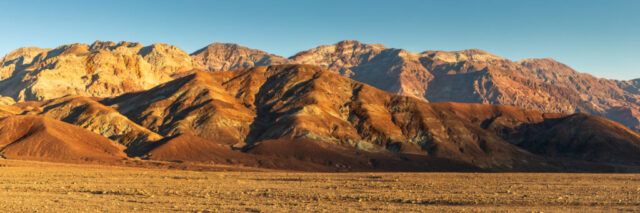 Mineral-stained ridgelines in golden late-afternoon light near Badwater Basin, Death Valley National Park, California, January