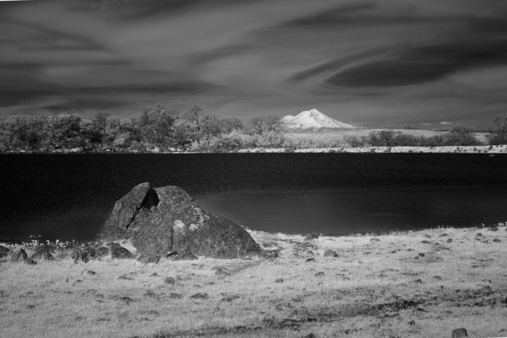 830nm infrared view of Mount Shasta beyond Hog Lake from Sacramento Riverbend Area, large volcanic boulder foreground