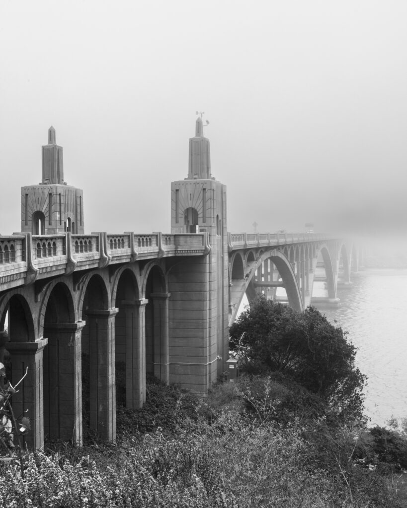 Isaac Lee Patterson Bridge spanning the Rogue River mouth at Gold Beach, Oregon, shrouded in coastal fog, black and white